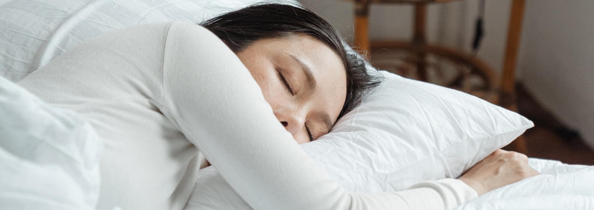 Man som ligger nedbäddad under filtar i soffan.