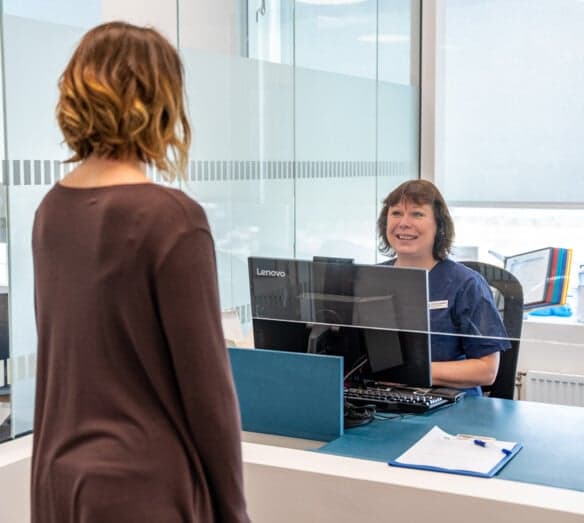 Patient som stÄr i reception Patient som stÄr i reception