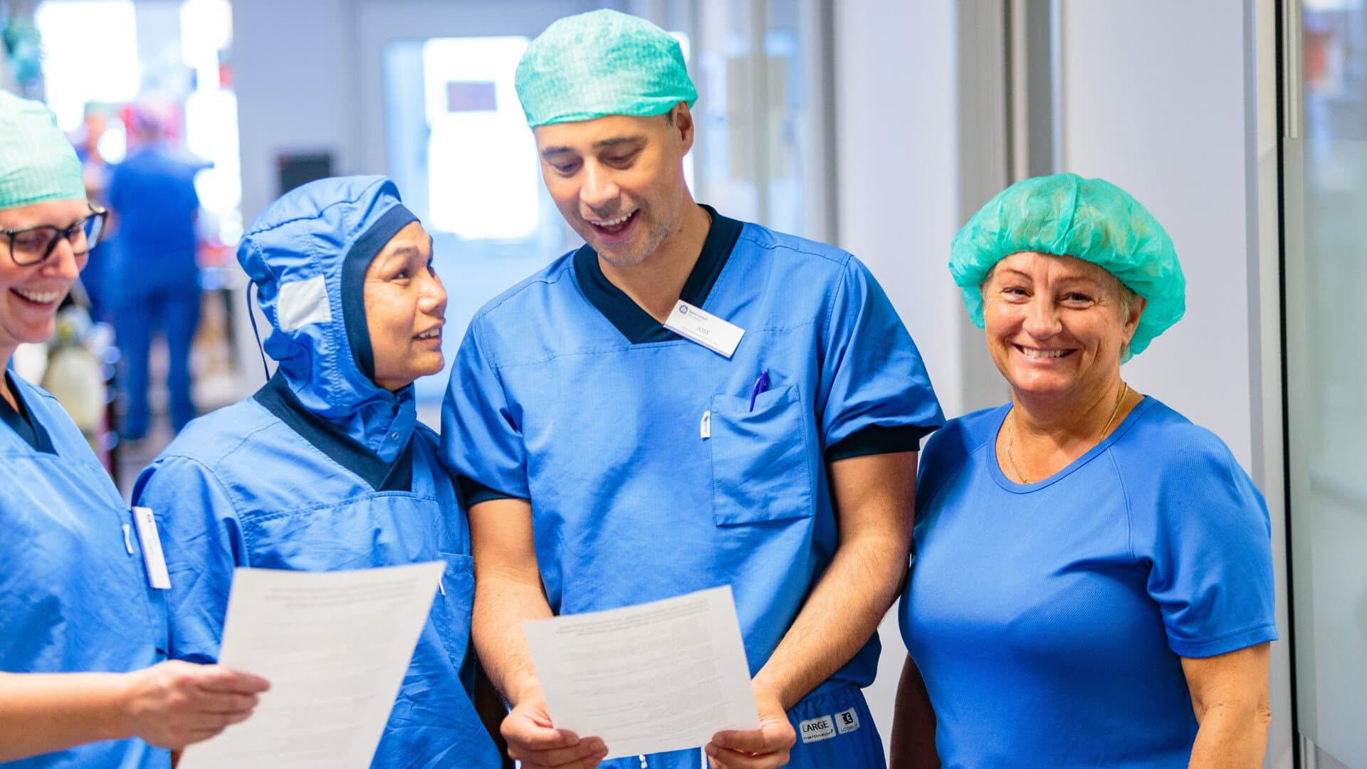 Personal på operationsavdelningen skrattar i korridor Personal på operationsavdelningen skrattar i korridor