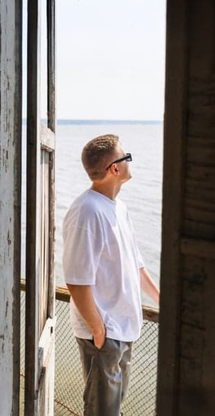 Man med solglasögon står på en balkong Man med solglasögon står på en balkong