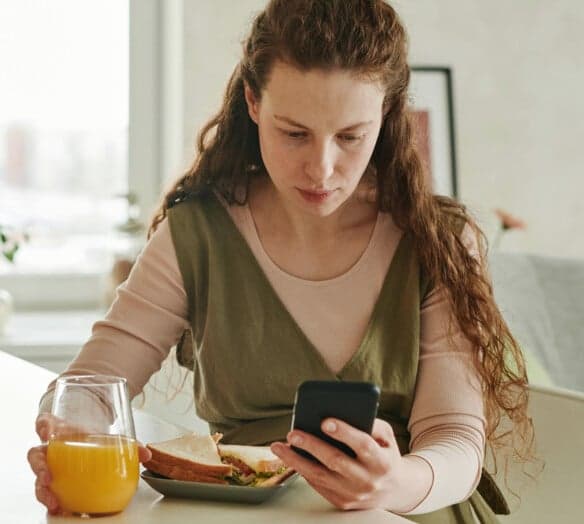 Kvinna tittar i mobilen Kvinna tittar i mobilen