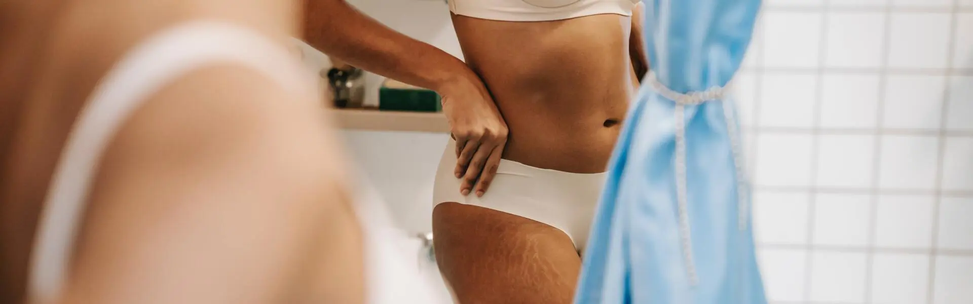 Kvinna i underkläder speglar sig i badrumsspegel. Kvinna i underkläder speglar sig i badrumsspegel.