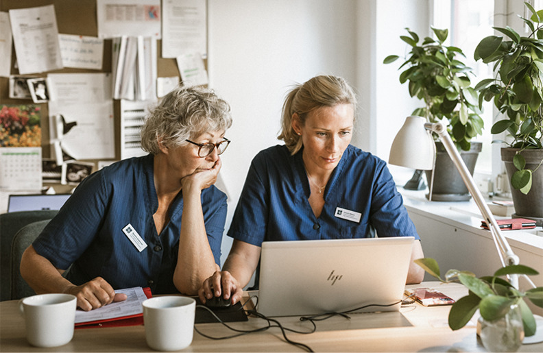 Agnetha och kollega sitter vid dator