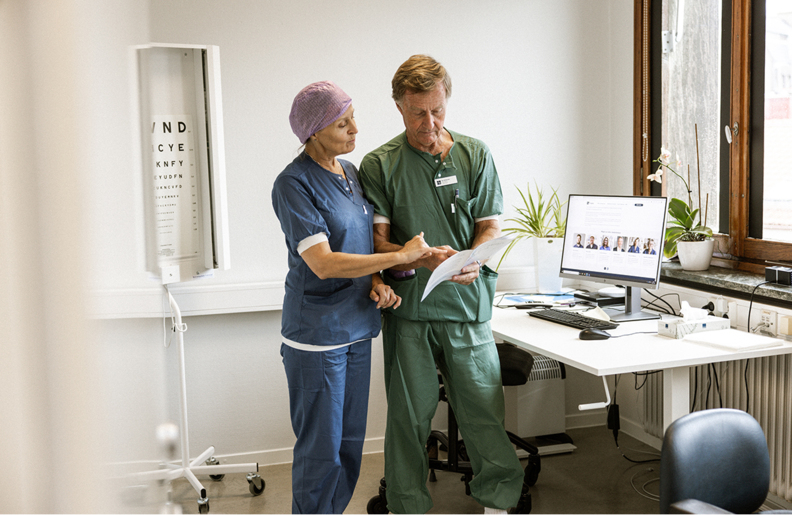 Medarbetare samtalar och tittar i papper. 