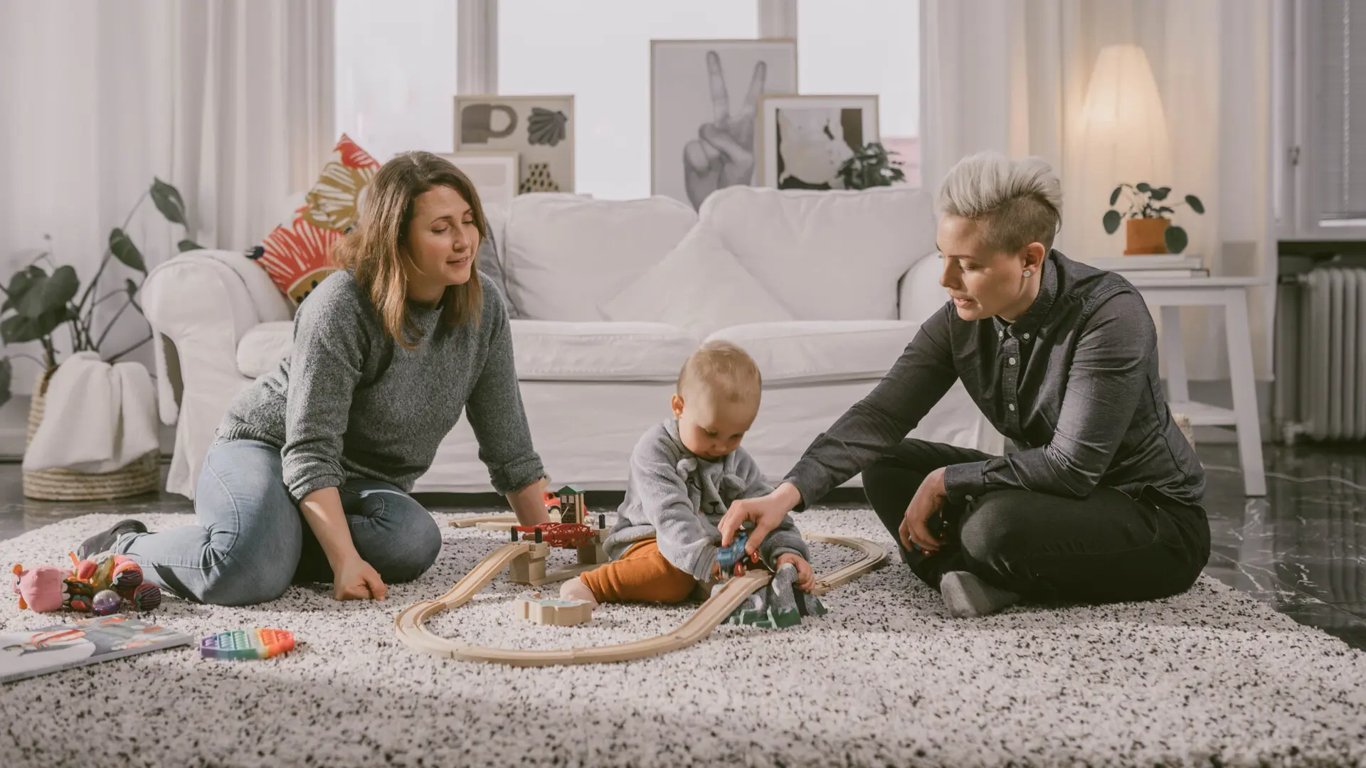 Mammor och barn leker på golvet 