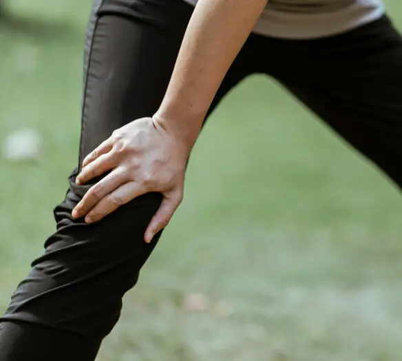 ett ben med en hand på sitt knä