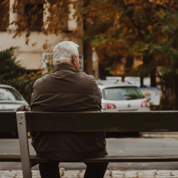 Man sitter på parkbänk Man sitter på parkbänk