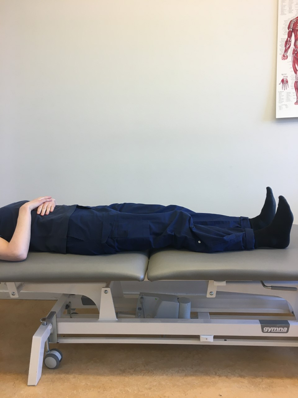 Person ligger platt p&aring; brits med h&auml;nderna avslappnat &ouml;ver magen. 