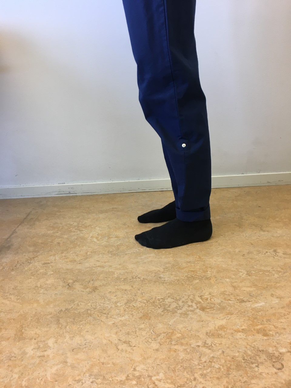 Person st&aring;r med b&aring;da f&ouml;tterna platt mot golvet.