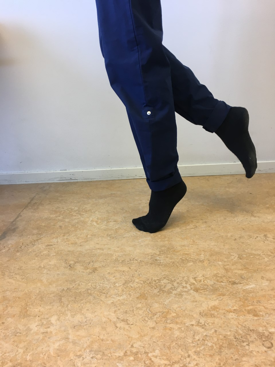 Person g&ouml;r t&aring;h&auml;vning med ena benet, andra benet n&aring;got lyft bak&aring;t. 