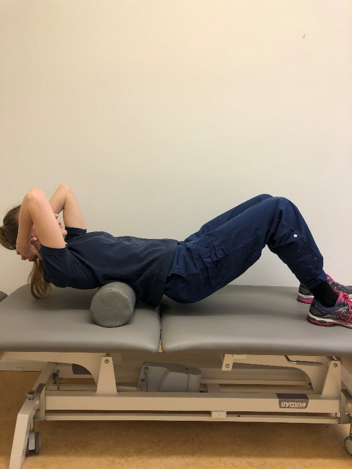 Tjej ligger p&aring; foamroller mitt p&aring; ryggen.