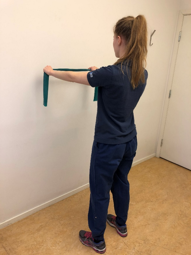 Tjej h&aring;ller bandet horisontellt str&auml;ckt med raka armar.