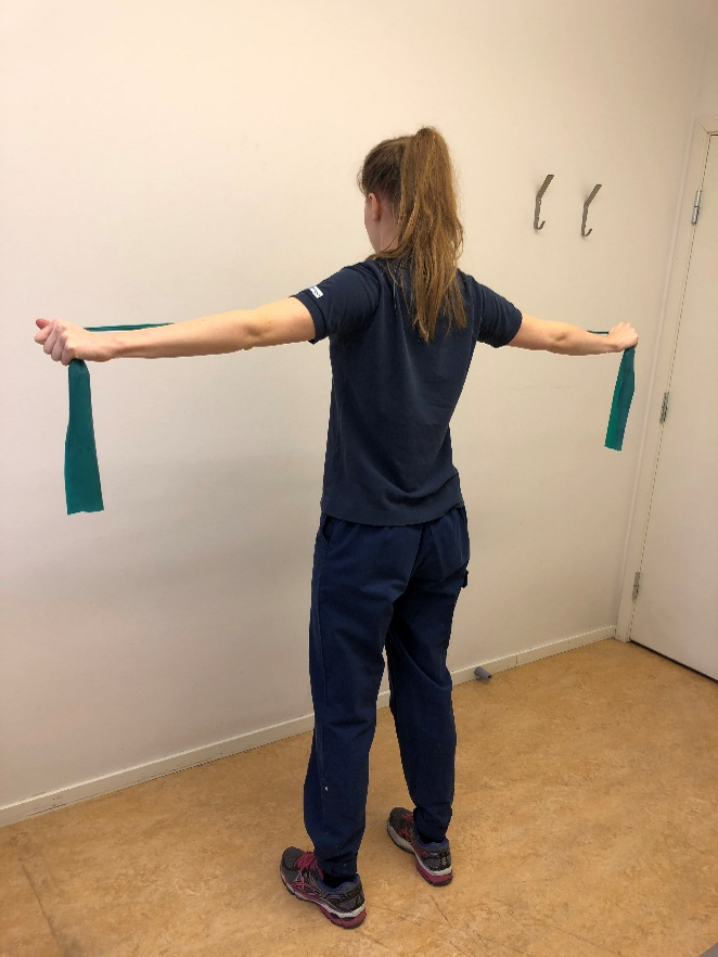 Tjej drar ut gummibandet horisontellt åt var sitt håll.