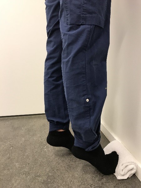 Tåhävning mot en hoprullad handduk, hälen dras uppåt.